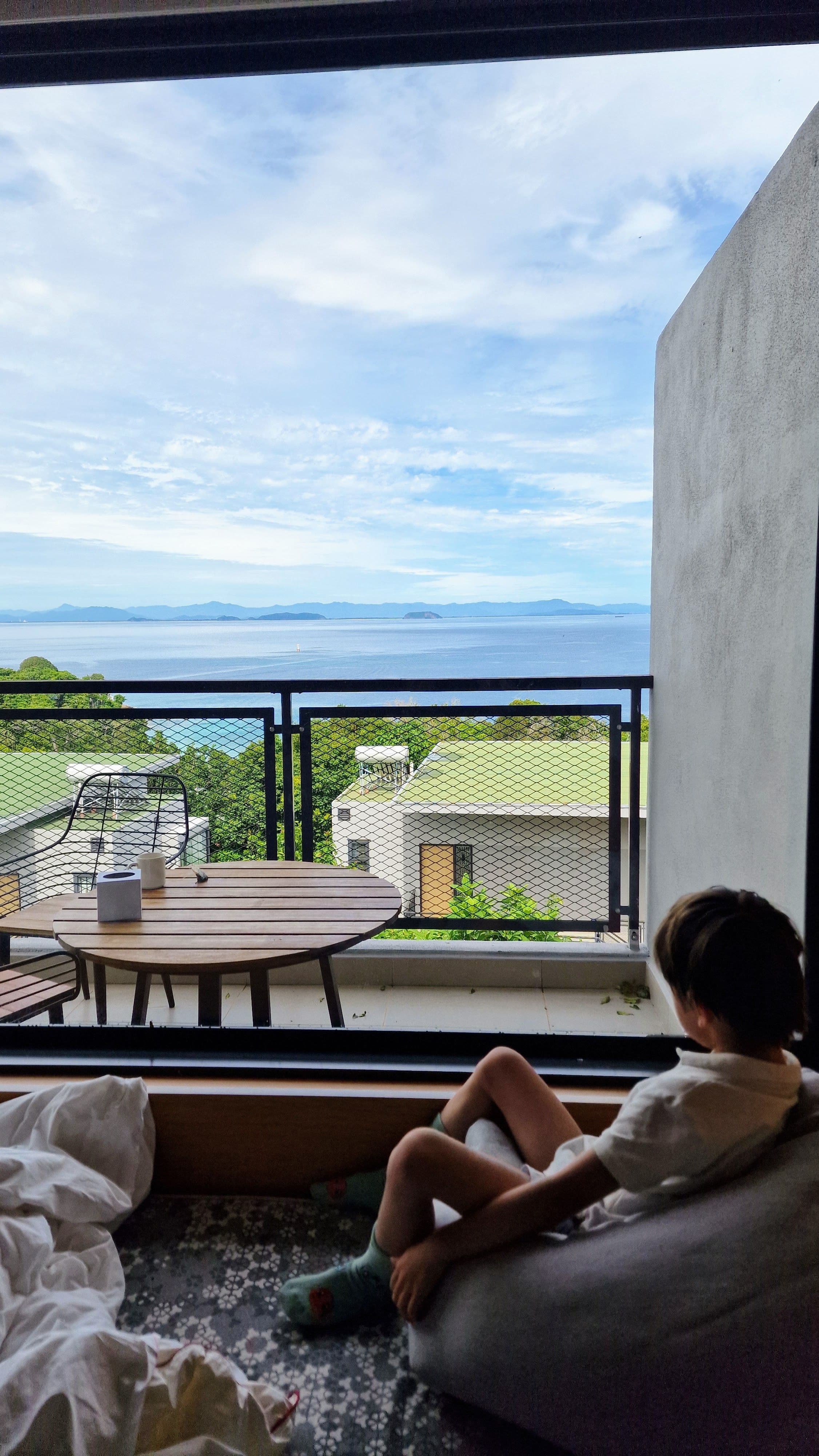 a child looking out the window to the ocean